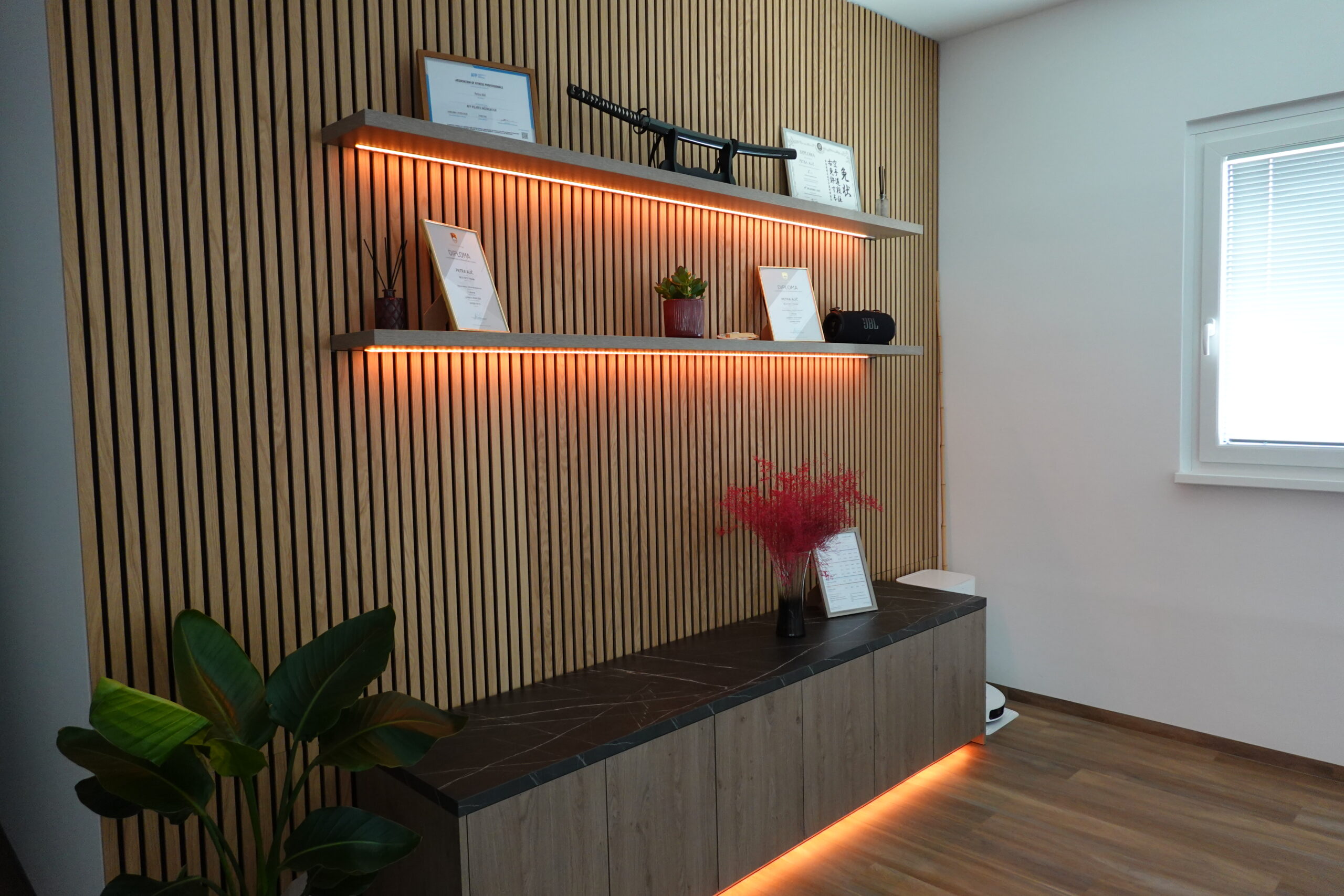 Lesena stena in ambientalna osvetlitev studia Pilates Plus Petra